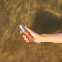 Hand holding a bottle under water of the ocean